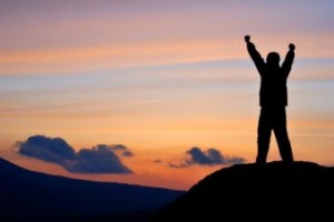 Man standing on the edge of rock on sunset.